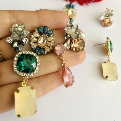 Brincos coloridos com pedras grandes e detalhes metálicos