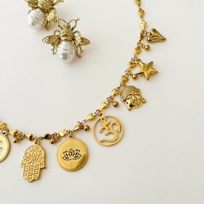 Colar dourado com pendentes simbólicos e brincos de abelha com pérolas