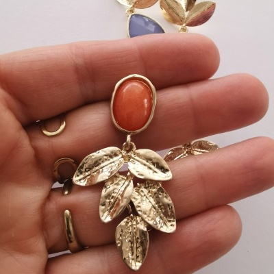 Brinco dourado com pedra oval laranja e folhas pendentes texturizadas