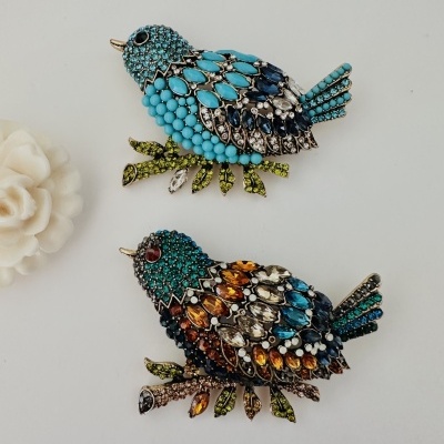 Broches de pássaros decorados com cristais coloridos