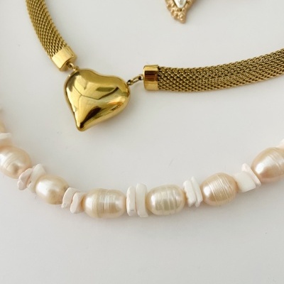 Colares dourado e de pérolas em fundo branco