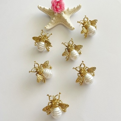 Broches de abelhas douradas com pérolas e estrela-do-mar decorativa com flor rosa