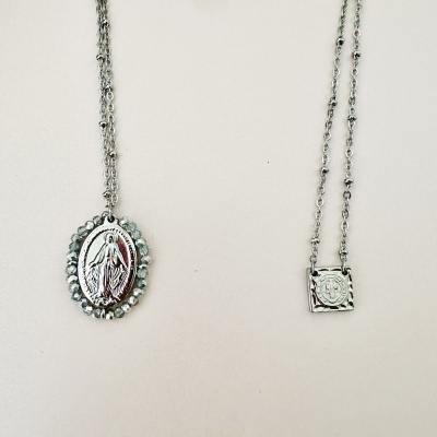 Dois colares prateados com pendentes distintos fundos claros