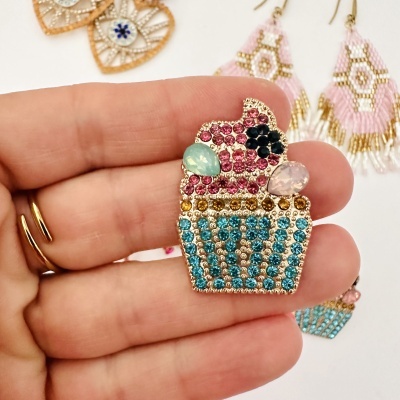 Broche em forma de cupcake com pedras preciosas coloridas e fundo com brincos de miçangas