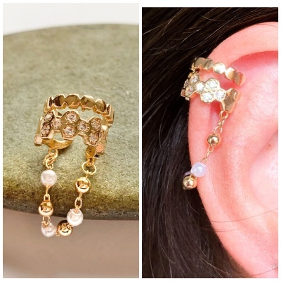 brinco ouro com pedras e correntes penduradas na orelha