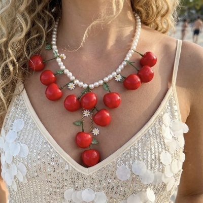 Colar com cerejas vermelhas e pérolas usado com vestido prateado