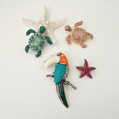 Broches decorativos de tartarugas, estrelas do mar e tucano com brilho sobre fundo branco
