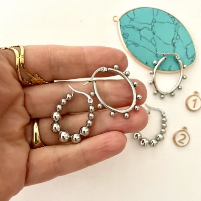 Brincos de argola em prata com contas esferas, decoração azul e etiquetas numeradas