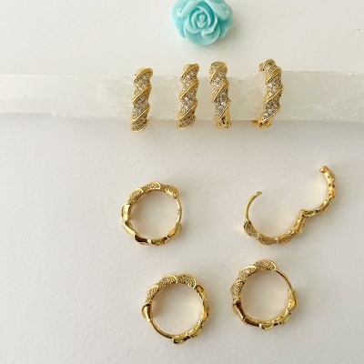 Conjunto de brincos dourados em argolas e detalhes com pedras brilhantes