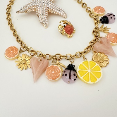 Colar dourado com pendentes de frutas, flores e corações em resina e metal