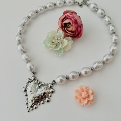 Colar de contas peroladas com pendente de coração prateado e flores artificiais coloridas