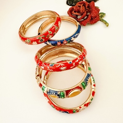 Quatro pulseiras douradas com esmalte decorativo colorido e flor vermelha decorativa