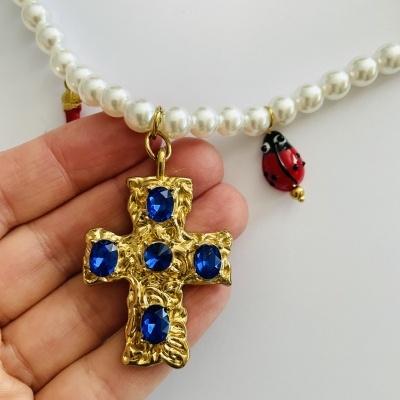 Colar de contas de pérola com pendente de cruz dourada azul e joaninhas vermelhas