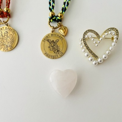 Dois medalhões dourados com cordões, broche de coração com pérolas e coração de pedra branca