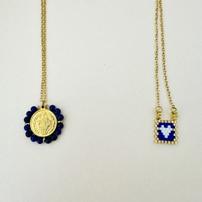 Dois colares dourados com diferentes pingentes em fundo branco