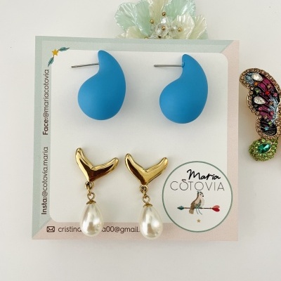 Conjunto de brincos azul e dourado com pérola em cartão Maria Costóvia em fundo branco