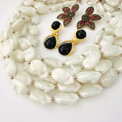 Colar de pérolas brancas com contas douradas e dois pares de brincos decorativos.