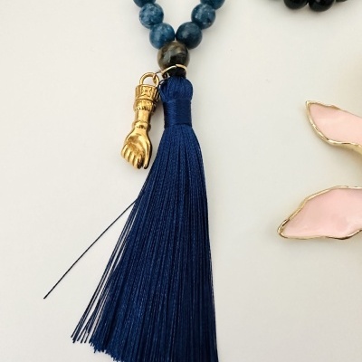 Colar de contas com pendente de franja azul e mão dourada