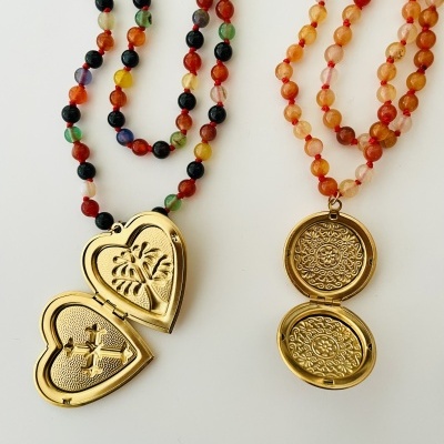 Dois colares com contas coloridas e pendentes medalhão dourados, pendente coração e pendente circular com padrão floral.