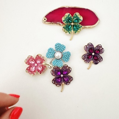 Conjunto de cinco broches florais coloridos com pedras e acabamento dourado