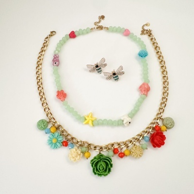 Conjunto de bijuteria com dois colares e brincos de abelha com cristais.