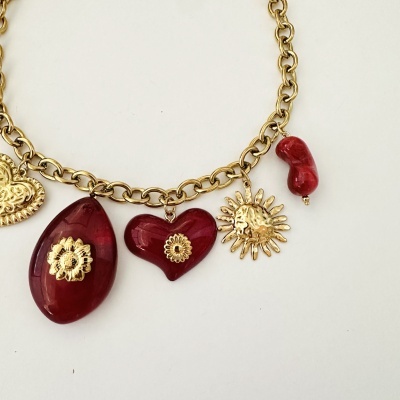 Colar dourado com pendentes vermelhos em forma de coração, gota, feijão e sol.