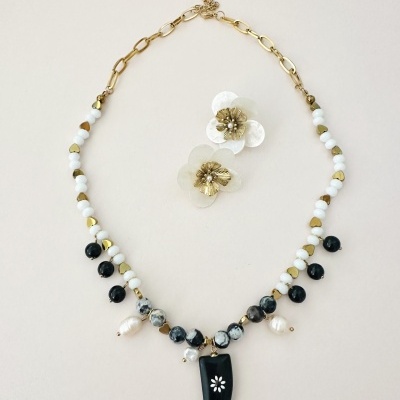 colar colorido com pingente preto e brincos florais transparentes