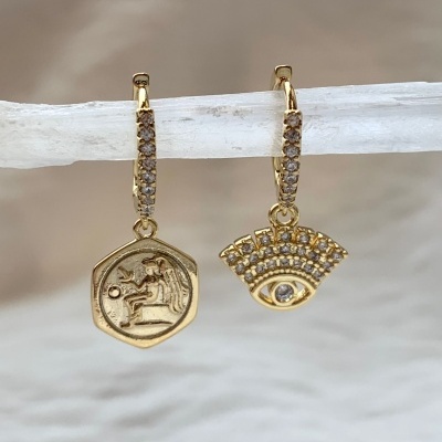 Brincos dourados com pendentes diferentes em barra branca