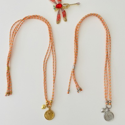 Duas pulseiras com cordão laranja e prateado e broche libélula dourada com detalhes coloridos