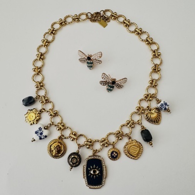 Colar dourado com vários pendentes e brincos em forma de abelha