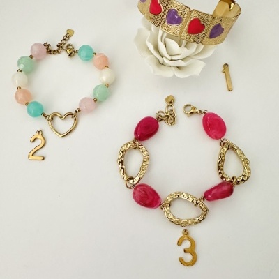 Pulseiras coloridas e douradas com símbolos de coração e números 2 e 3