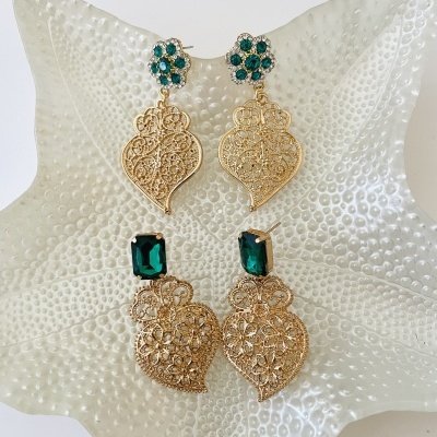 Dois pares de brincos dourados com pedras verdes em prato prateado texturizado