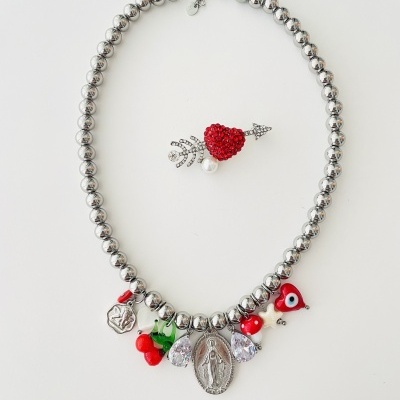Colar prateado com vários pendentes coloridos e brochinha de coração vermelho com seta.