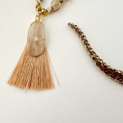 Colar com pendente oval e franjas e pulseira dourada com pedras castanhas