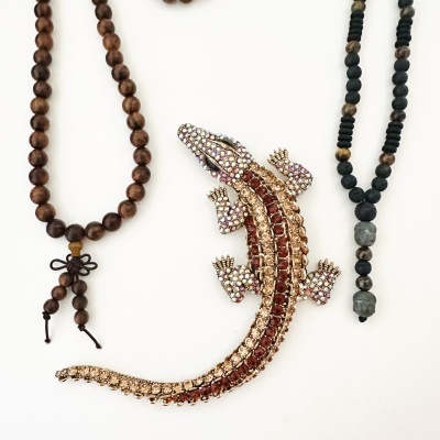 Colares de contas e broche de crocodilo com pedras brilhantes