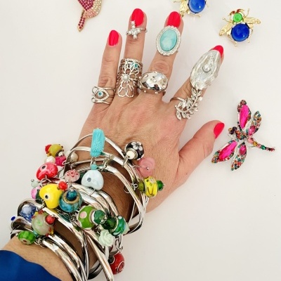 Mão com joias coloridas variadas em fundo branco
