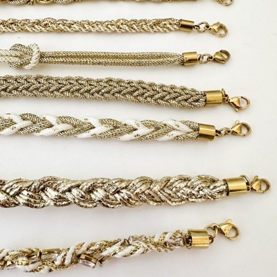 Seis pulseiras entrelaçadas douradas e brancas com fechos dourados