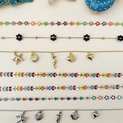 Diversas pulseiras coloridas com temas marinhos e florais em metal, esmaltadas e com pedras decorativas