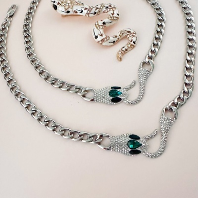 Colar de corrente prateada com cabeça de animal brilhante e decoração de serpente