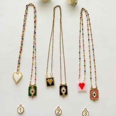 Cinco colares coloridos com pingentes variados em fundo branco