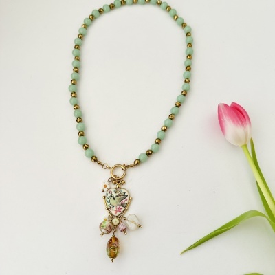 Colar de contas verdes com pendente decorativo e tulipa ao lado