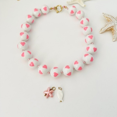 Colar de contas brancas com corações cor-de-rosa e pendentes de concha e peixe