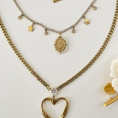 Colares dourados e prateados com pedrarias e pingentes, sobre fundo branco