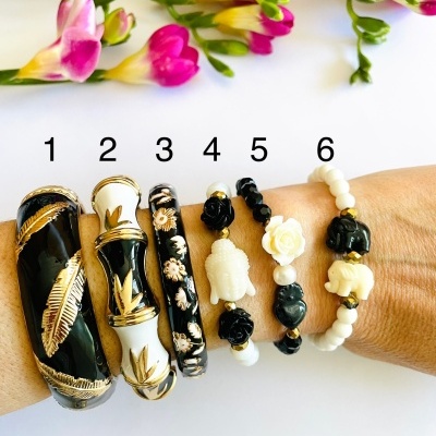 Seis pulseiras de materiais variados em braço com flores coloridas ao fundo