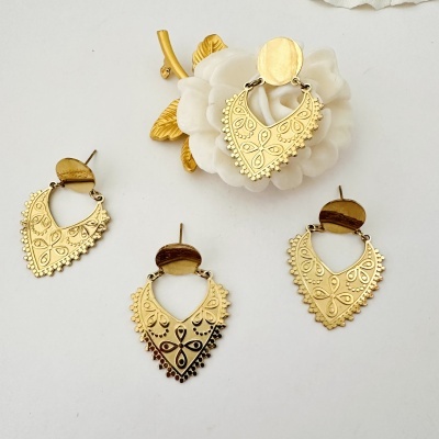Brincos dourados com padrão floral em fundo branco