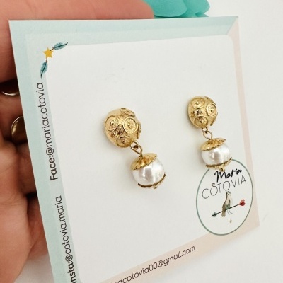 Brincos dourados com pérola e cartão branco com texto Maria COTOVIA