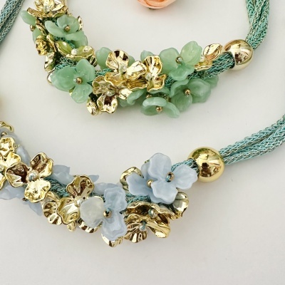 Pulseiras verdes com flores douradas e azul claro
