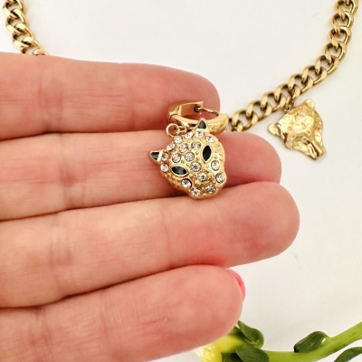 Colar dourado com pendente cabeça de onça e pedras brilhantes