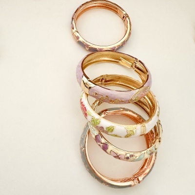 Conjunto de pulseiras rígidas coloridas com decoração floral