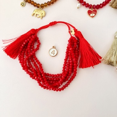 Pulseira vermelha com franjas e contas em fundo branco